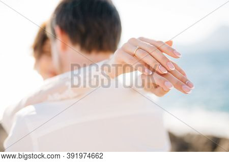 Bride And Groom Are Hugging On The Rocky Beach Of The Mamula Island, The Bride Put Her Hands On The 