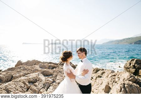 Bride And Groom Are Hugging On The Rocky Beach Of The Mamula Island Near Arza Fortress