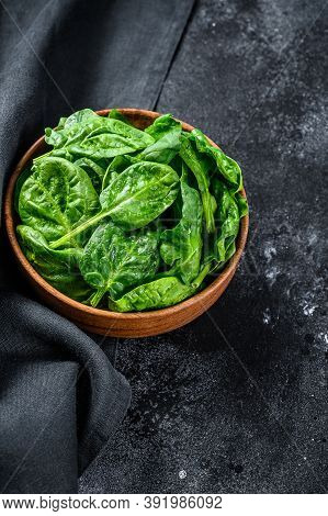 Fresh Spinach Leaves In A Wooden Bowl. Black Background. Top View