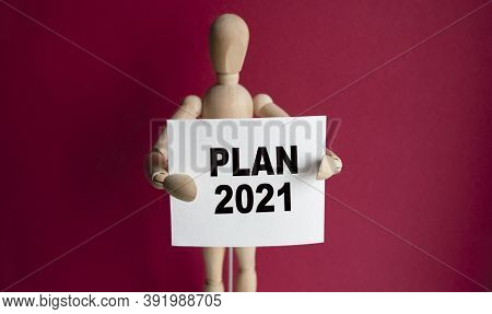 The Wooden Man Holds A White Sign With The Text Plan 2021 In His Hands. The Content Of The Lettering