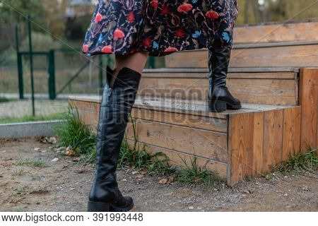 A Lady Walks Up The Stairs And In Burgundy Pall And Biret, In Black Clothes, In The Fall Against The
