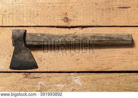 Old vintage axe closeup on a wooden background, household hand tools