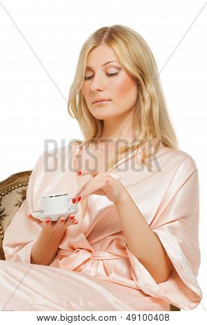 Beauriful girl in nightgown drinking coffee