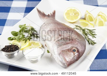 A Red Sea Bream With Spices, Lemon Slices And Herbals