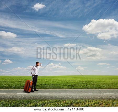 długa droga do wakacji. młody biznesmen trzyma worek i czekamy