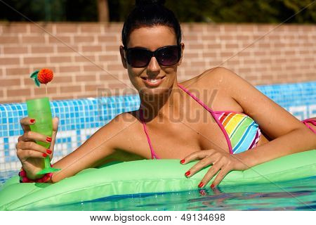 Sexy donna posa sul materassino in piscina, Sorridere, prendere il sole.