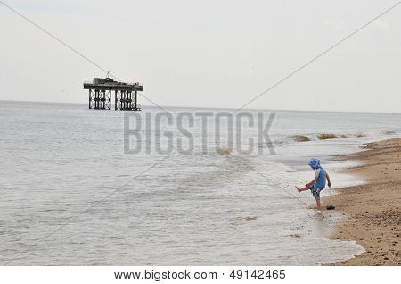 Small child kicking sand on a beach