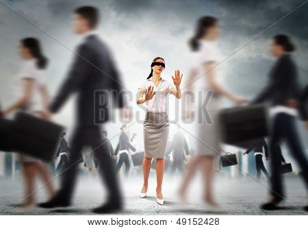 Businesswoman in blindfold among group of people