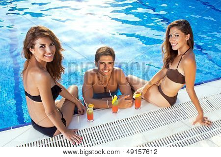 Happy Man Between Two Women At The Swimming Pool