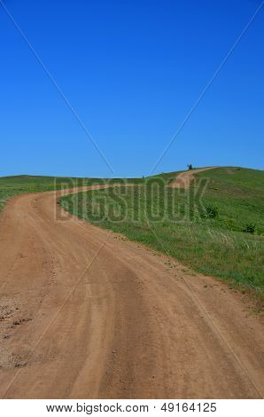 Winding road in the green field.