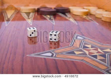 Twee dobbelstenen met reflectie op houten handgemaakte Backgammon bord Is