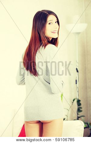 Sexy playful woman in long sweater at home 