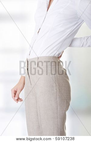 Woman with back pain holding her aching hip 