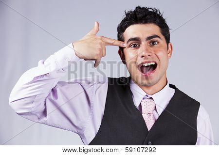 Young businessman despair pointing his finger to his head like shooting a gun 