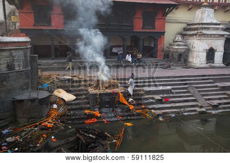 KATHMANDU, NEPAL - DEC 20: During the cremation ceremony along the holy Bagmati River in Bhasmeshvar Ghat at Pashupatinath temple, Dec 20, 2013 in Kathmandu, Nepal.