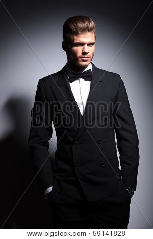 happy elegant fashion man with hands in pockets smiling to the camera