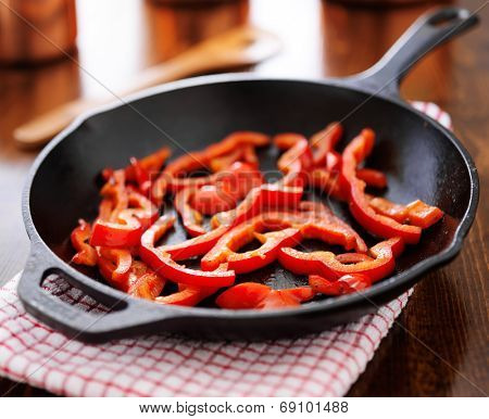 fried red bell peppers cooling in iron skillet on dish towl