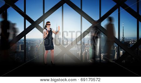 Redhead businesswoman in a blindfold against room with large window looking on city