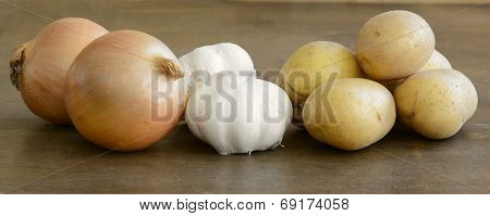 Long close up of fresh potatoes, onions, and garlics