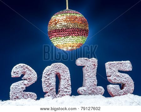 Frosted 2015 New Year digits and glistering ball over dark blue background