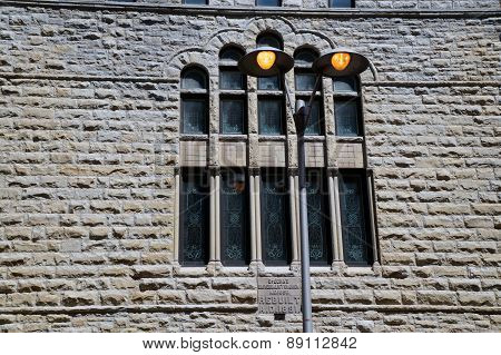 Lamppost in Front of the Stained Glass Windows of an Old Church