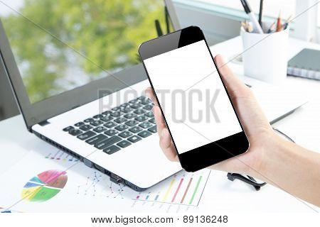 Closeup Hand Hold Smartphone And Laptop On Desk Background Community Device In Office
