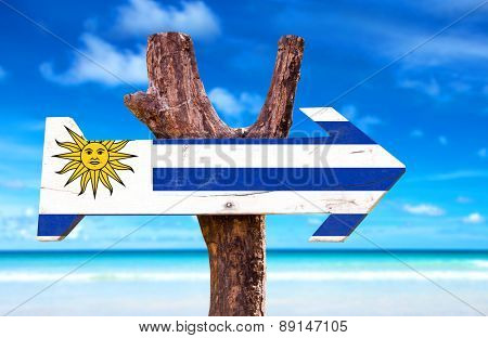 Uruguay Flag wooden sign with beach background