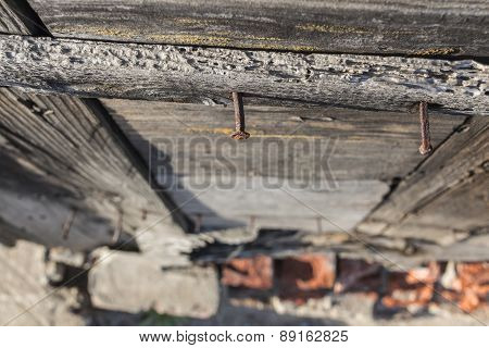 Rusty Vintage Nails In Wooden Wall And Blurred Red Bricks On Ground