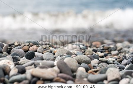 pebbles on the beach with a wave. Shallow focus