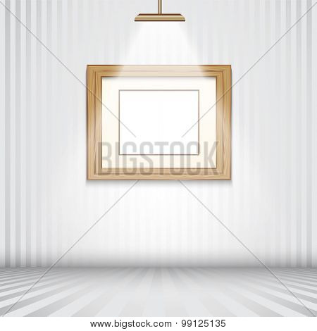 Spotlit room with empty wooden picture frame