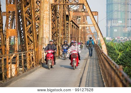 People ride motorbike in Long Bien bridge in Hanoi, Vietnam.