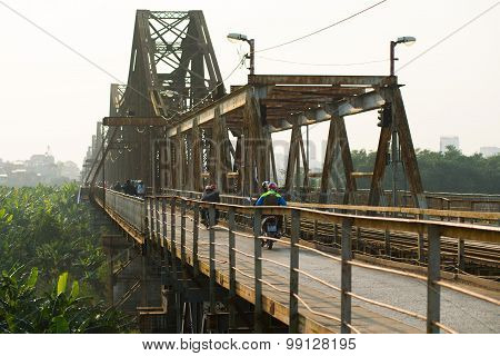 People ride motorbike in Long Bien bridge in Hanoi, Vietnam