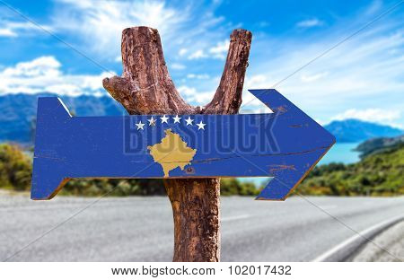 Kosovo Flag wooden sign with road background