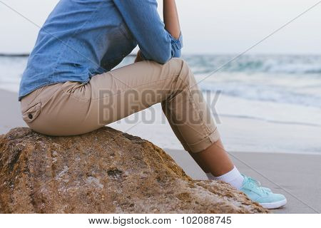 Beautiful Slim Woman Sitting On A Rock By The Sea