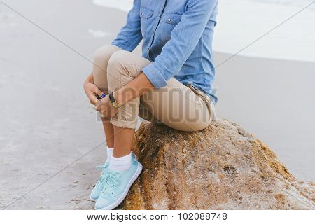 Beautiful Young Woman Sitting On A Rock By The Sea
