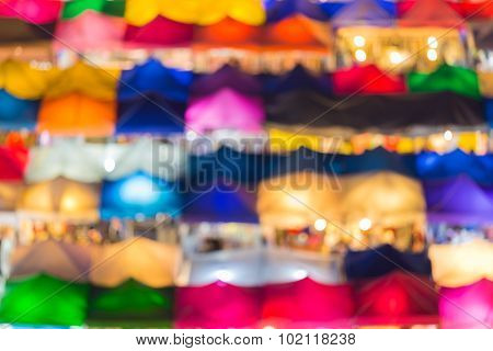 Colourful blurred bokeh lights, aerial view of weekend market at night