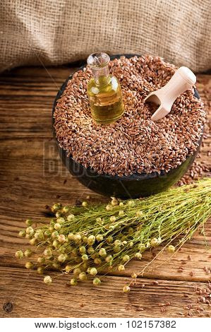 Mortar Bowl Full Of Flax Seeds With Spoon And Oil