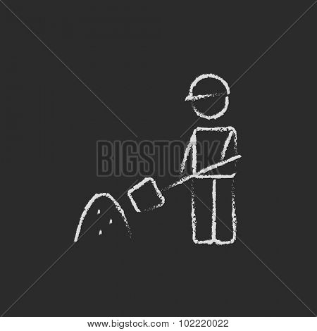 Man with shovel and sand hand drawn in chalk on a blackboard vector white icon isolated on a black background.