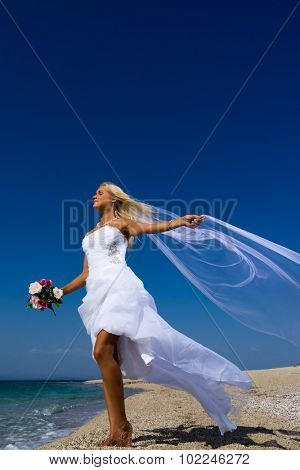 Young bride in white wedding dress  on the beach in Greece