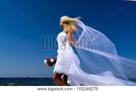 Young bride in white wedding dress  on the beach in Greece