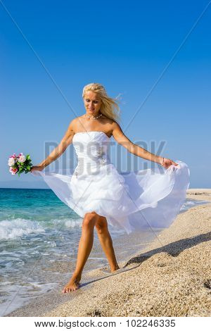 Young bride in white wedding dress  on the beach in Greece