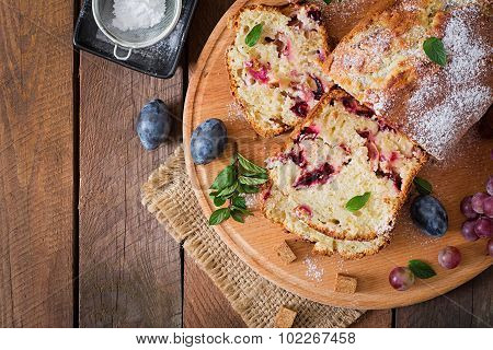 Juicy and tender cupcake with plums and grapes