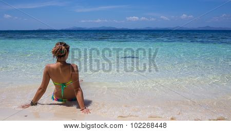 Young woman reaxing on the beach at exotic resort