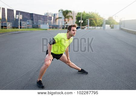 Young handsome athlete playing sports on the road in summer morning