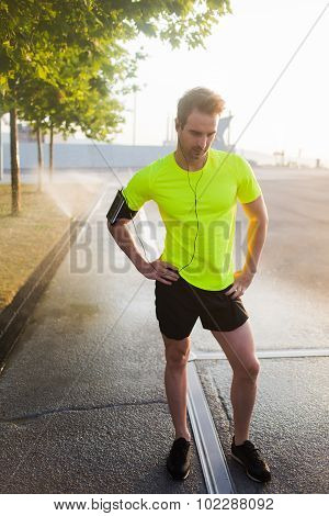 Young handsome male runner thinks plan further movement morning run