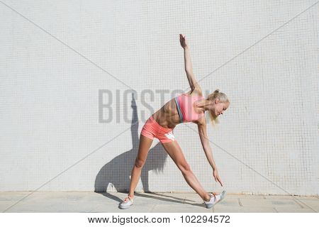 Young fit woman doing warm up exercises before run