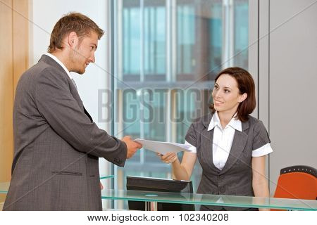 Young caucassian secretary assisting businessman