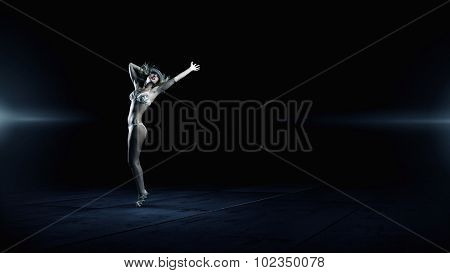 Hot young dancing woman in white bikini on dark background