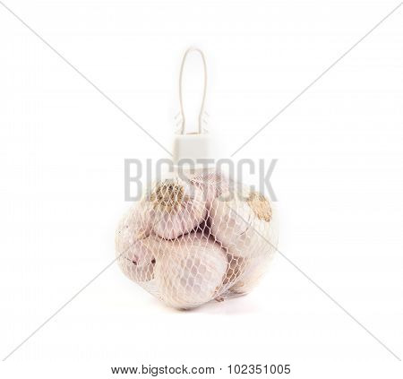 Garlic In Net Bag For Sale In Market On White Background