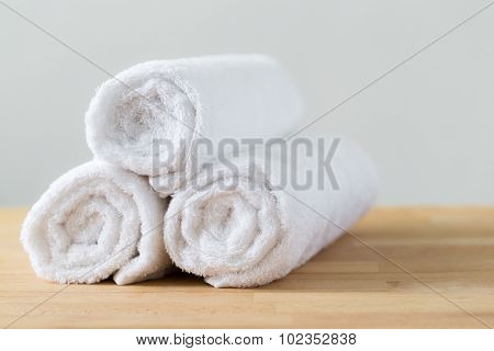 White spa towels pile on wooden table